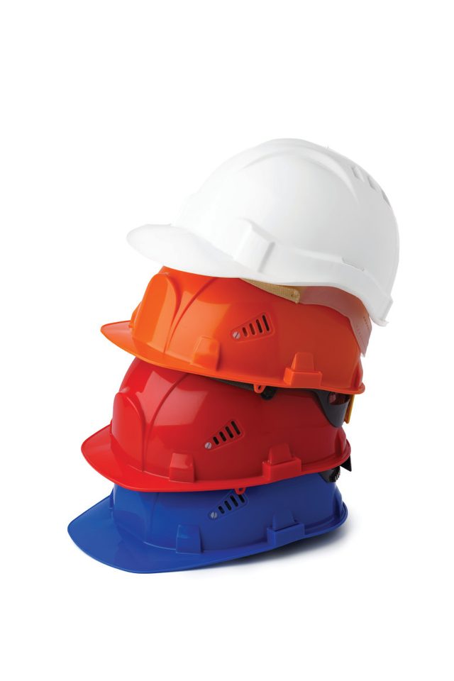 A stack of safety helmets in white, red, orange and blue.
