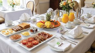 Breakfast buffet laid out with pastries, fruit and juice.